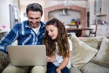 Father and daughter using laptop