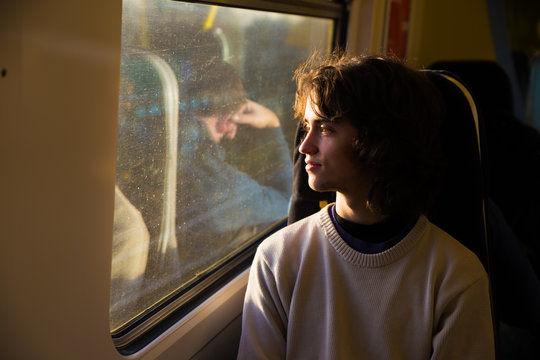 Teenager on a train looking out the window