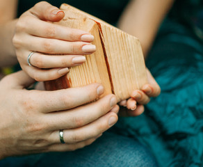 The male and female hands holding a small wooden decorative house