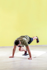 Handsome young man at gym, exercising with friction pads.