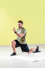 Handsome young man at gym, exercising with friction pads.