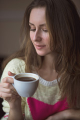 Young girl, sitting in a cafe with cup of coffee