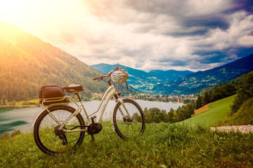 Naklejka na ściany i meble e-bike standing above a beautiful landskape with a lake - e-powe