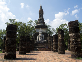 Obraz premium Sitting buddha , ruins of ancient temple and pillars, Sukhotai, UNESCO heritage site