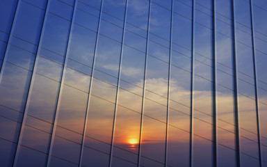 Reflection of sunset sky in metal wall of office building