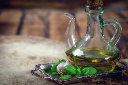 Olive oil Bottle with basil and garlic - wooden background with copy space
