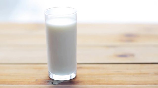 full glass of milk on wooden table