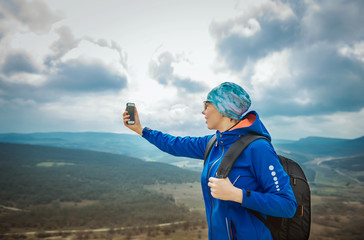 girl tourist on background of the mountains with a mobile phone