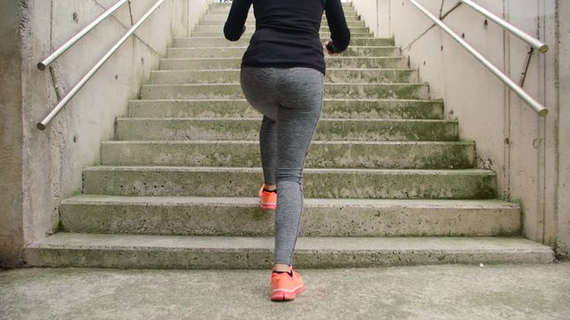 Step up exercise on urban stairs. Woman training hiit outside. Female athlete doing knee raises workout.