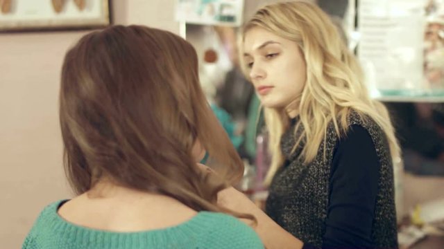 Hairdresser sprays hairspray on the model's hair