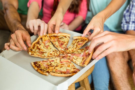 Cropped image of friends eating pizza