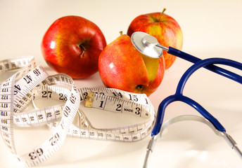 Stethoscope with red apples on a white background