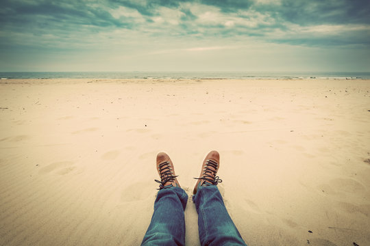 First Person Perspective Of Man Legs In Jeans On The Beach