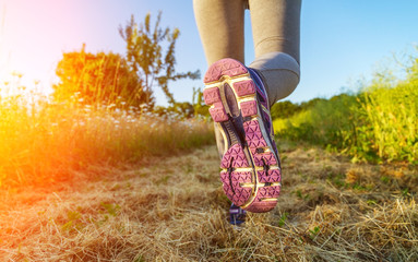 Woman running at sunset in a field