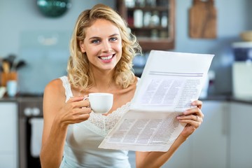Portrait of beautiful woman holding newspaper