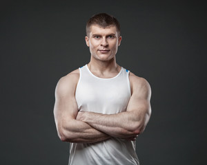 Young muscular man isolated on gray background