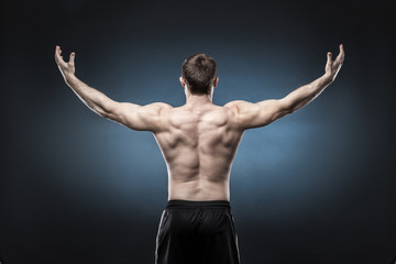 Fototapeta na wymiar Muscular male back isolated on dark blue background