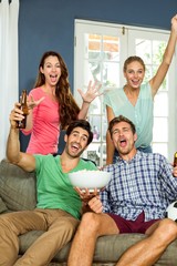 Portrait of smiling friends shouting at home