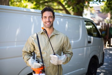 Smiling worker with pesticide sprayer - 107521558