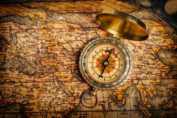 Fototapeta na wymiar Old vintage golden compass on ancient map