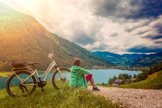woman with e-bike resting above a lake/e-power 28