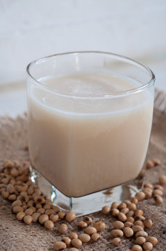Soy milk in white glass on wooden background