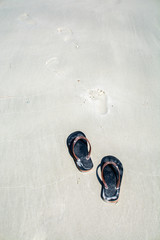 Take off your shoes on the beach with footprints
