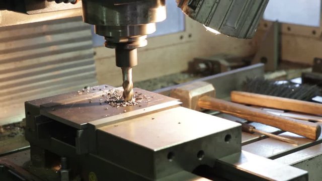Drilling machine making a hole in a steel bar