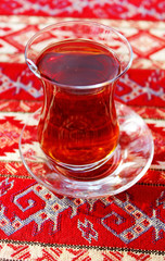 Turkish tea in traditional glass cup on handmade arabic ornament