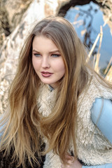 Naklejka premium Blonde girl in fashionable clothes posing outdoors