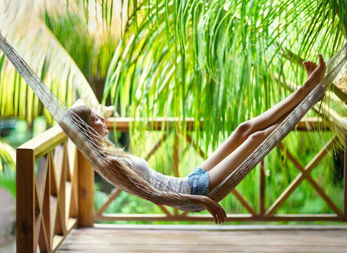 Young woman relaxing in hammock in a tropical resort