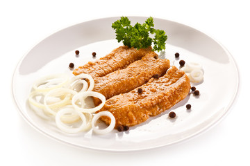 Marinated fried herring fillets on white background 