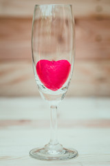 red heart inside wine glass on wood background, loving drink wine concept.