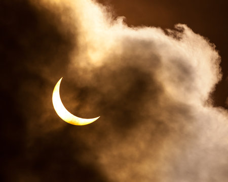 Partial solar eclipse through clouds