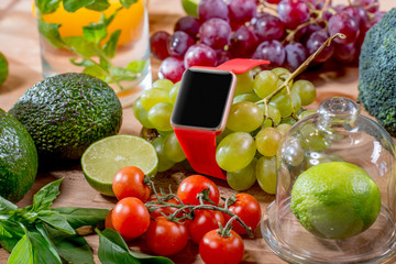 Smart watch with empty screen and green fruits on the table. Smart watch technology for healthcare