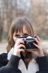 portrait of  pretty tourist taking photographs with vintage retro camera