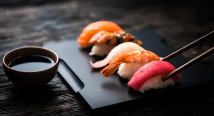 Papier Peint photo Bar à sushi gros plan de sushi sashimi serti de baguettes et de soja