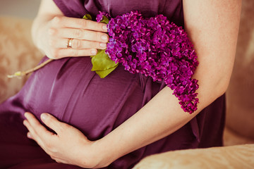 Lilac in the hand of expectant woman