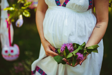 Pregnant girl in the white dress with lilac