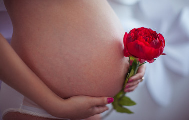 Pregnant with a red pionic in her hands