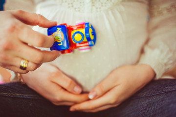 Tiny toy train on the belly of pregnant
