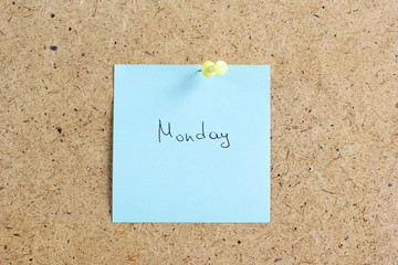 Monday written on color sticker notes over cork board background