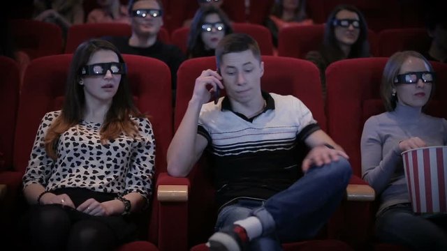 Man talking by phone at cinema