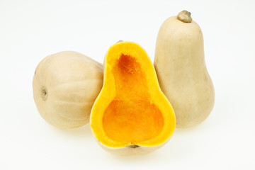 Naklejka na ściany i meble Butternut squash fruits, one cut half, on white background.
