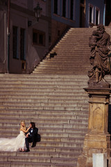 Sensual romantic newlywed couple sitting  on old baroque stairs