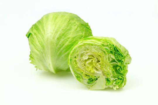 Iceberg lettuce and one cut half, on white background.