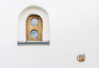 Authentic small window in the wall of the church