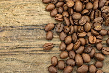 Coffee beans on the right side of rustic wooden background.