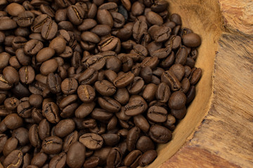 Coffee beans in rustic wooden bowl.