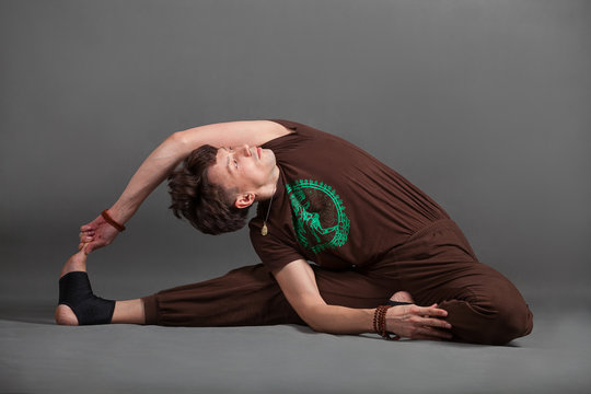 beautiful man doing yoga parivritta dzhanu shirshasana